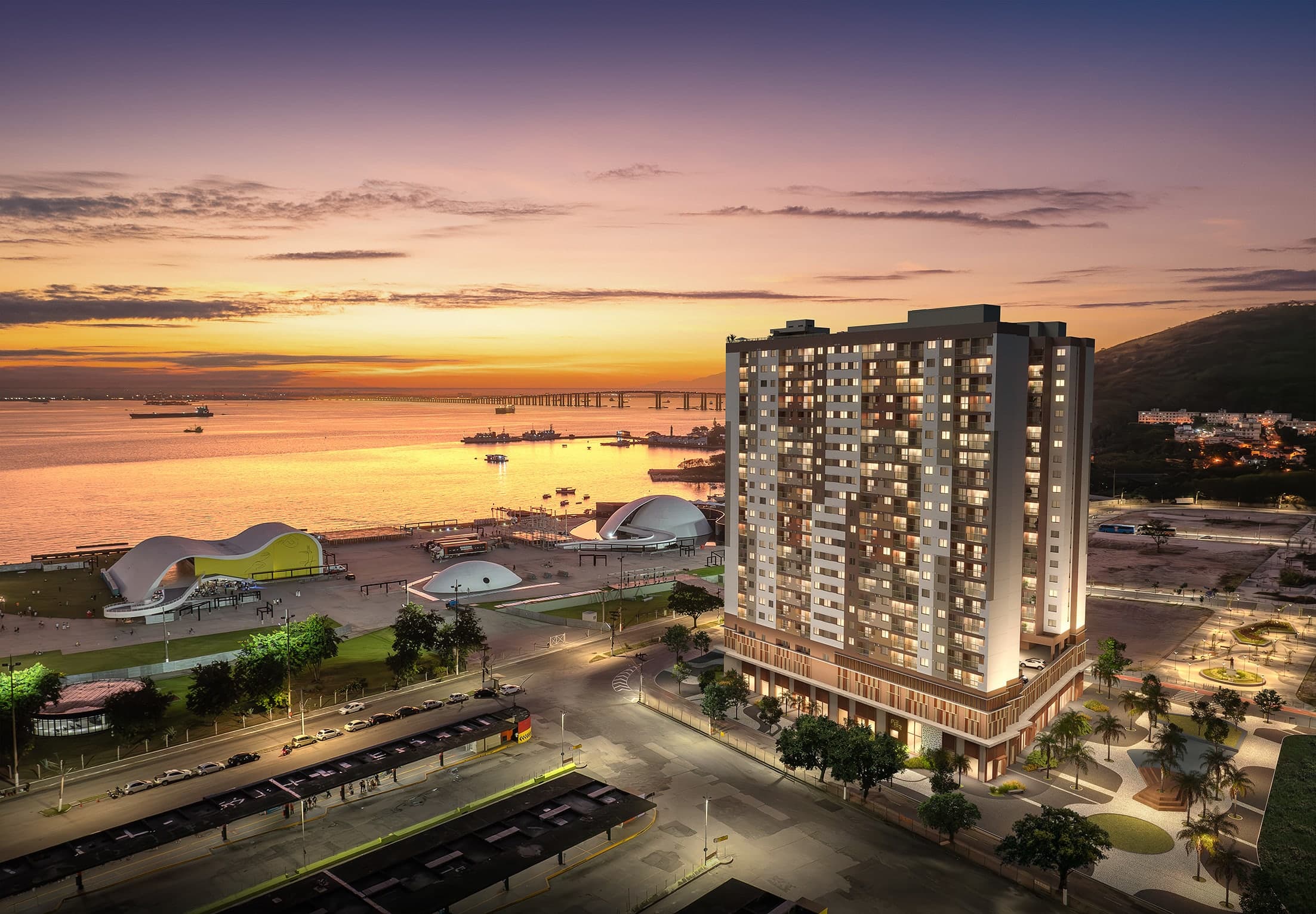 Empreendimento residencial da Cury Construtora iluminado ao entardecer, com vista para o mar.